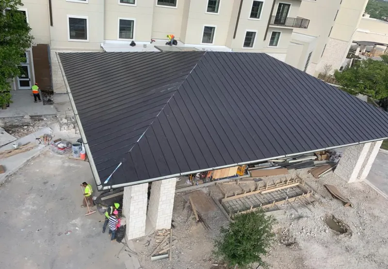 Metal roofing installation team working on a commercial building in Seaside